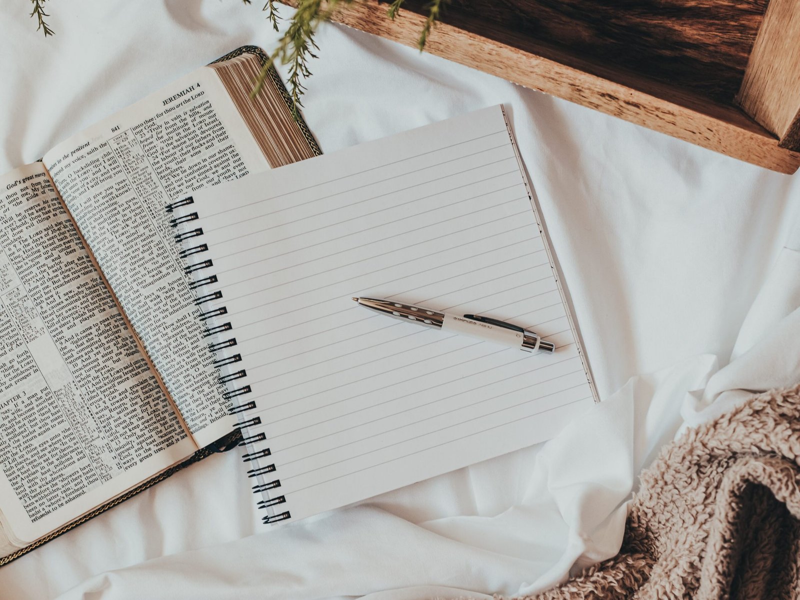 journal on a bed with bible and coffee